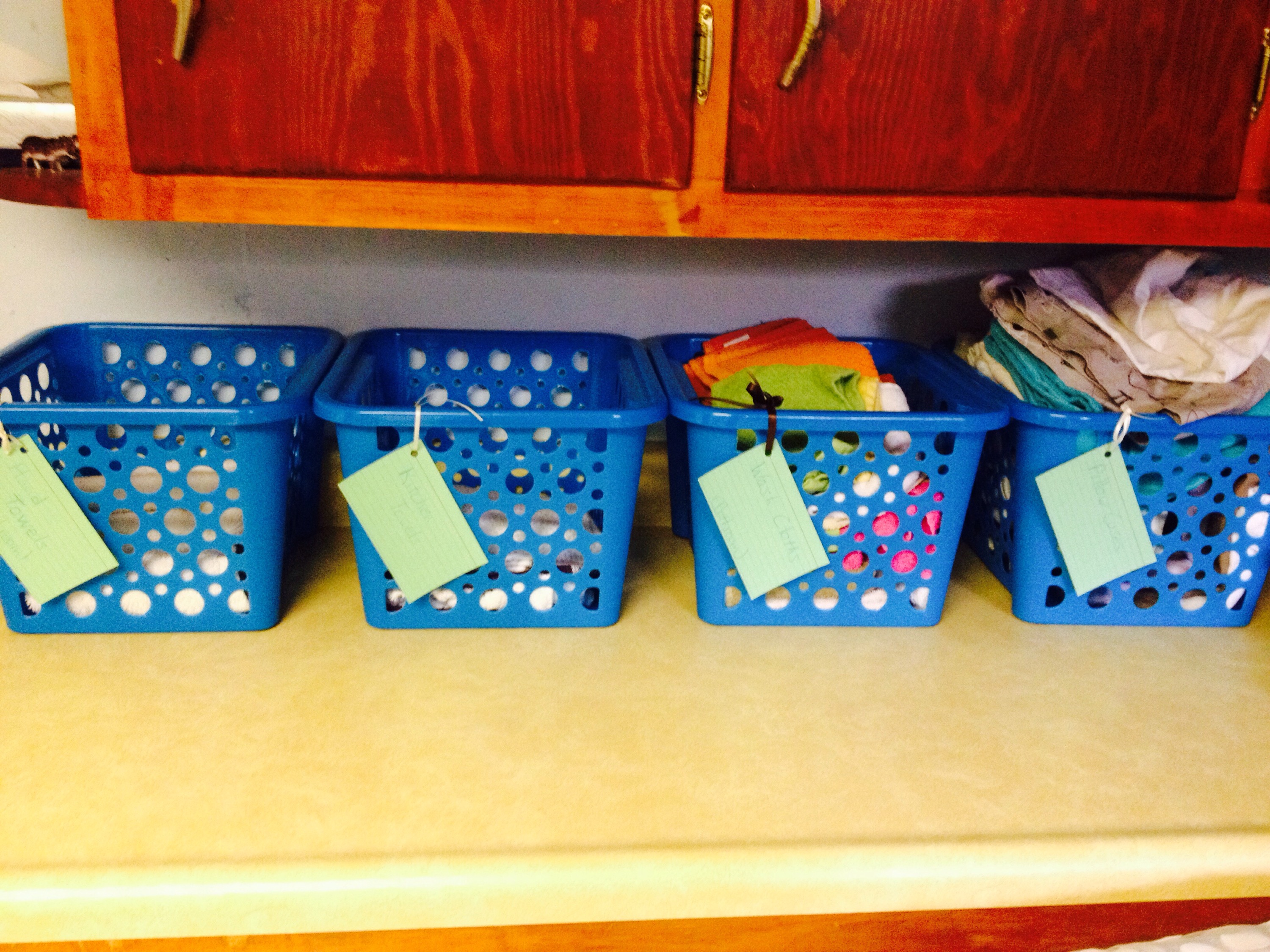 A smart solution to the small non-clothing stuff that ends up with your laundry. In her laundry room, Erin has small bins for wash clothes, hand towels, pillow cases, and the like. The labels are just index cards and ribbon. Easy peasy!